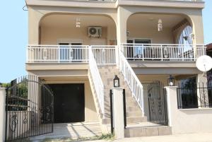 a house with white stairs and a black gate at House Stella in Keramotí