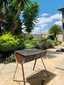 uma grelha de metal num suporte num jardim em Perchment view Apartment em Lusaka