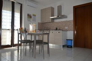een keuken met een tafel en stoelen in een kamer bij I Corbezzoli in Porto Torres