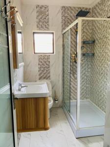 Perchment view Apartment في لوساكا: حمام مع حوض ودش ومرحاض