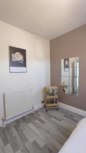 a room with a bed and a chair in it at Flat 2, Close to all amenities Shared bathroom in Cardiff
