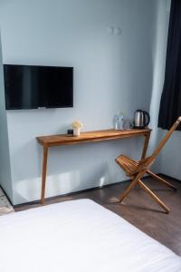 a wooden desk with a television on a wall with a chair at Veda Royal Suite in Duzce