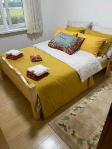 a yellow bed with two towels on top of it at Vikendica Leona in Laktaši