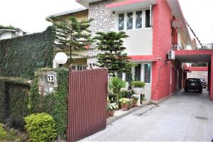 a red fence in front of a red building at Islamabad Lodges in Islamabad