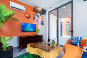 an orange living room with a table and a tv at Wabi Sabi Villa * Hồ Bơi Thác Nước 140 m2 * Phòng Karaoke Thủy Cung in Vung Tau
