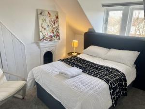 a bedroom with a bed and a fire place at Golden Triangle Townhouse in Norwich