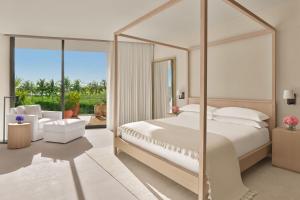 a bedroom with a large white bed with a large mirror at The Riviera Maya EDITION at Kanai in Playa del Carmen