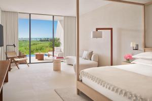 a bedroom with a bed and a living room at The Riviera Maya EDITION at Kanai in Playa del Carmen