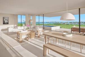 a living room with white furniture and a view of the ocean at The Riviera Maya EDITION at Kanai in Playa del Carmen