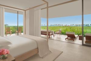 a bedroom with a bed and a patio with a view at The Riviera Maya EDITION at Kanai in Playa del Carmen