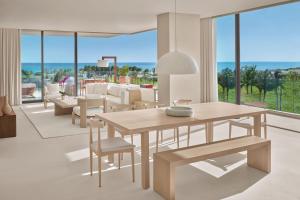 a living room with a wooden table and chairs at The Riviera Maya EDITION at Kanai in Playa del Carmen