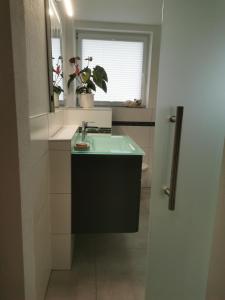 a bathroom with a sink and a mirror at Ferienhaus Marla in Schwebda