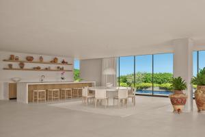 a kitchen and dining room with a table and chairs at The Riviera Maya EDITION at Kanai in Playa del Carmen