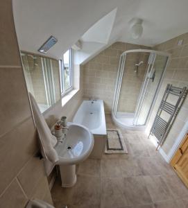 y baño con lavabo y bañera. en Rosemary Cottage, Uley, Gloucestershire en Uley
