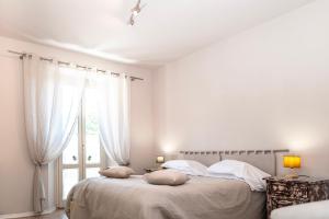 um quarto branco com 2 camas e uma janela em Il risveglio del Poggio em Castiglione dʼOrcia