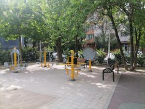 a park with yellow playground equipment on a sidewalk at Luxury 4-rooms, 2-bathrooms, Obor area in Bucharest
