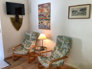 2 Stühle und eine Lampe in einem Zimmer in der Unterkunft Magnolia Garden in Miskolc