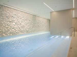 a swimming pool with a stone wall at Hotel Kompas in Dubrovnik