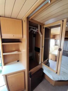 ajar door of a small room with a bed in it at Kamping, trailer Molly in Ulcinj