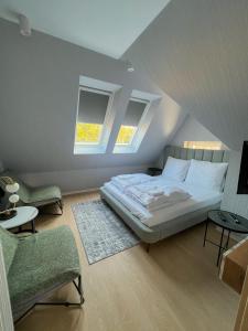 una camera con un grande letto e due finestre di Cavaldi Aparthotel a Dziwnów