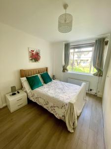 Schlafzimmer mit einem Bett und einem Fenster in der Unterkunft Impeccable 2-Bed Apartment in London in London
