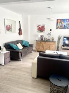 ein Wohnzimmer mit 2 Sofas und einer Gitarre in der Unterkunft Impeccable 2-Bed Apartment in London in London