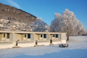 un bâtiment dans la neige avec un banc devant lui dans l'établissement Fleischer's Motel, à Vossevangen