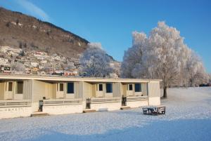 um edifício na neve com um banco à frente em Fleischer's Motel em Vossevangen