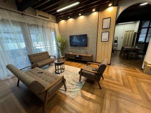 - un salon avec un canapé et une télévision dans l'établissement Rumah Hijau Homestay, à Alor Setar