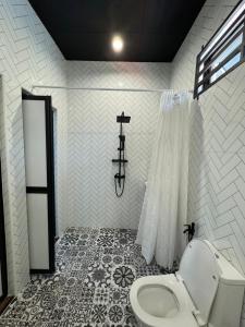 La salle de bains est pourvue de toilettes et de carrelage. dans l'établissement Rumah Hijau Homestay, à Alor Setar