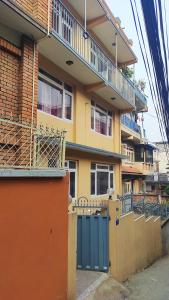 un edificio giallo con un cancello blu davanti di Budget Backpacker's Hostel a Patan