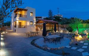 a patio with a table and chairs in front of a house at Anelia Serene Villa in Sfakaki