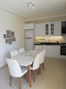 cocina con mesa y sillas blancas en una habitación en Genç Apart, en Muğla