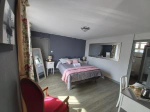 1 dormitorio con 1 cama con almohadas rosas en LA PASSIFLORE, en Azé