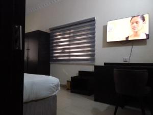 um quarto com uma cama e uma televisão de ecrã plano em st Theresers apartment B2 em Lekki