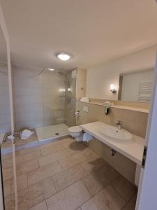 a bathroom with a sink and a toilet and a shower at Hotel Burg Wanzleben in Wanzleben