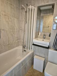 a bathroom with a tub and a sink and a toilet at COASTAL CHALET at Kingsdown Park with Pool & Tennis Court on-site No 64 in Kingsdown