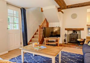 a living room with a table and a tv at Dolphin Cottage in Wiveton