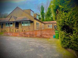 ein Backsteinhaus mit einem Zaun davor in der Unterkunft Aldridge in Chipstead