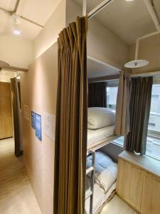 日初青旅 Sundaily Hostel 北車 في تايبيه: غرفة بسريرين بطابقين في غرفة