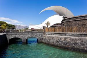 un pont sur une rivière avec un bâtiment en arrière-plan dans l'établissement Home2Book Pleasant & Design Apt Santa Cruz Center, à Santa Cruz de Tenerife
