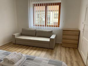 sala de estar con sofá y ventana en Penzion Trödler, en Brod nad Dyjí