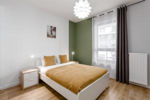 um quarto com uma cama e uma grande janela em Warsaw City Apartments em Varósvia