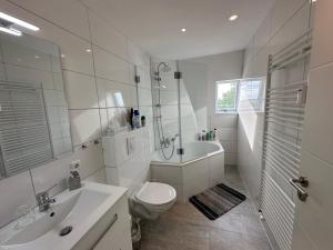 biała łazienka z toaletą i umywalką w obiekcie Zur schönen Aussicht I 90 m² I Idyllisch I Zuhause w Dortmundzie