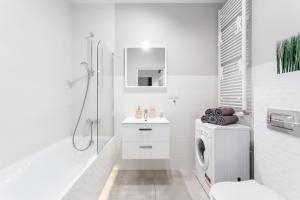 a white bathroom with a washing machine and a sink at Warsaw City Apartments in Warsaw +64 photos