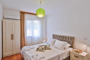 a bedroom with a large white bed with a window at Çınarlar Apart SC Blok in Kaş