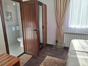 uma casa de banho com um WC e uma mesa de vidro em Vasilevi House em Devin