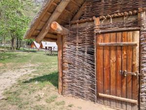 un edificio in legno con una porta in legno e un campo di Parco Archeologico Valdieri a Valdieri
