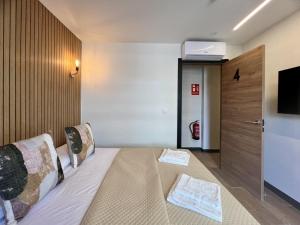 a hotel room with a bed and a flat screen tv at Boutique Palacio in Alicante