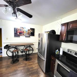 a kitchen with a stainless steel refrigerator and a table at A Princely Experience! in Stoughton